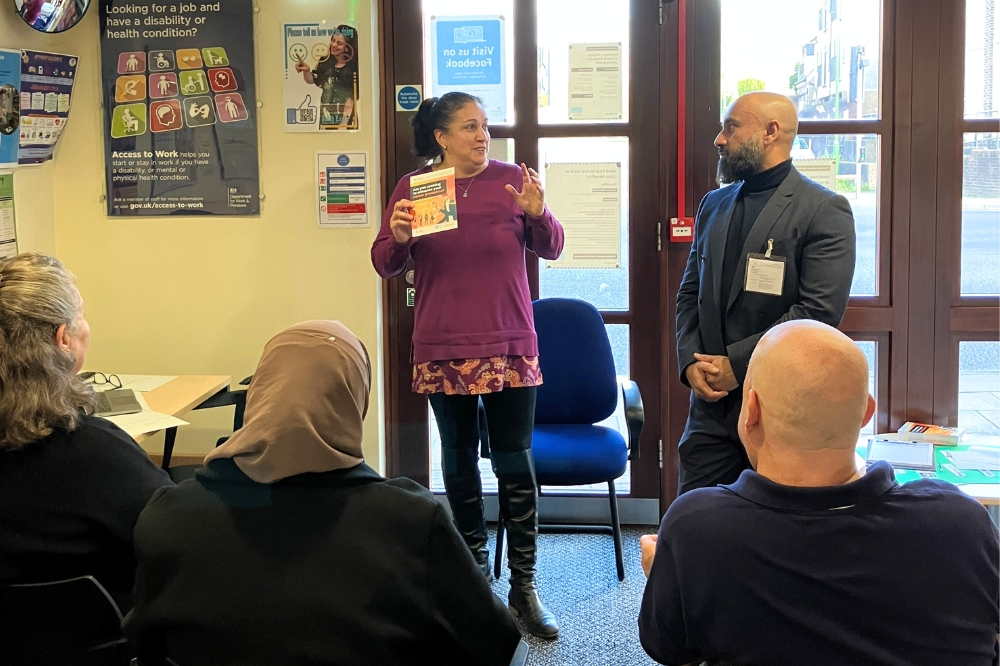 Zaia Marebet and Sha Rahman standing at the front of a room leading a workshop to a mixed group of participants.