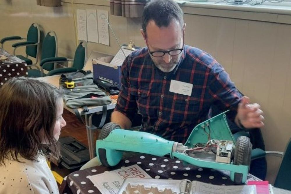 Picture of a member of the community hub repairing a hover board