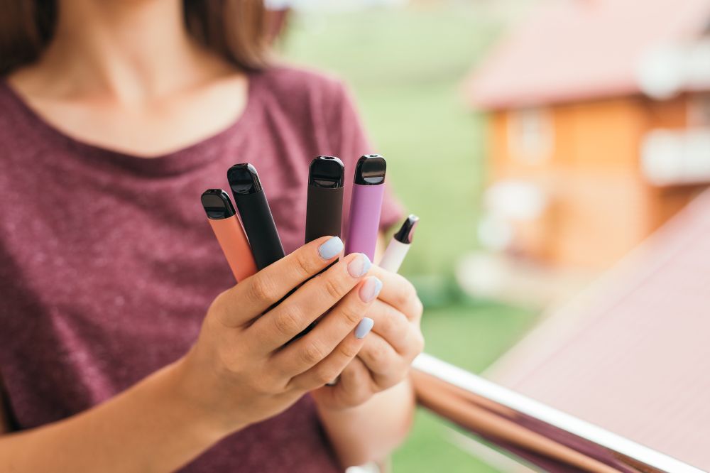 Young person holding five vapes