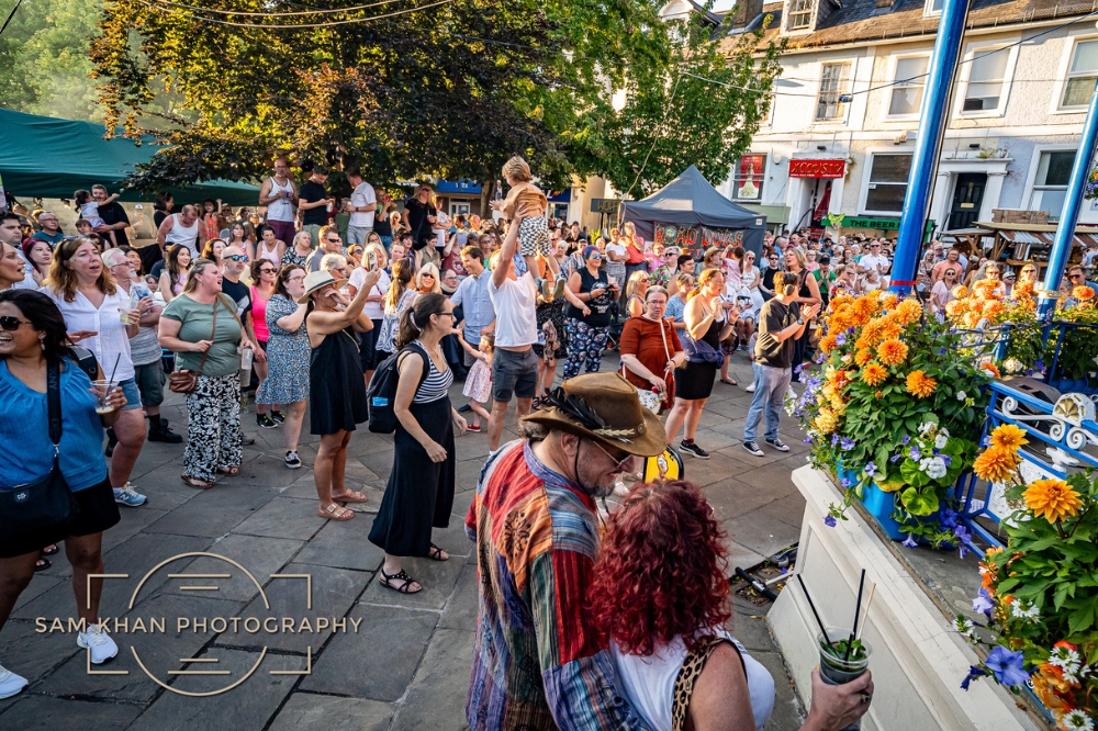 A large group of adults and children enjoying music in Horsham's Carfax