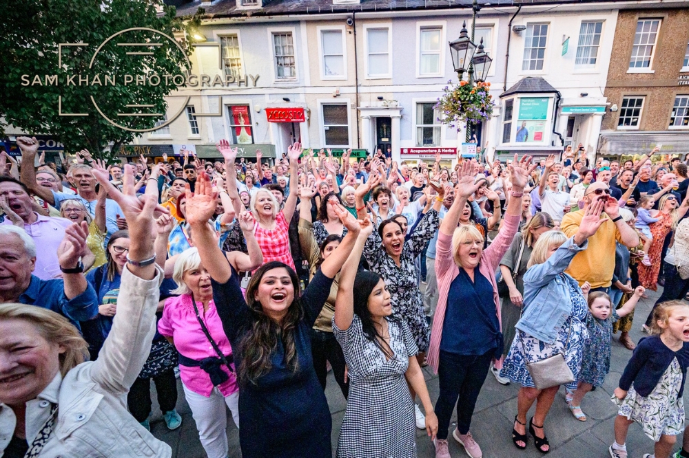 Image showing a crowd with arms raised enjoying music in the Horsham Carfax. 