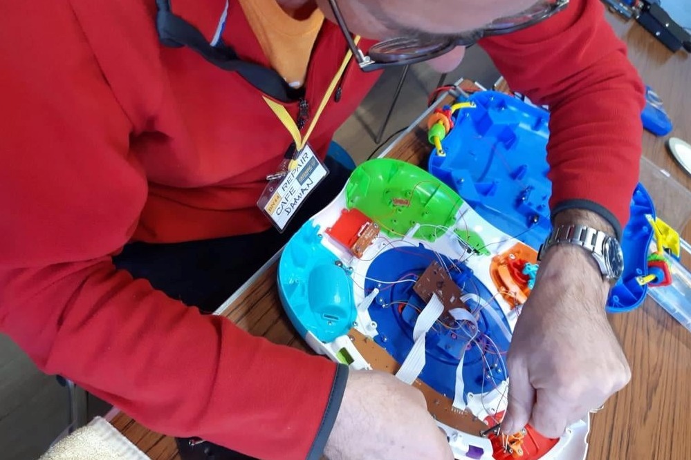 Picture of a member of Greening Steyning fixing a toy 