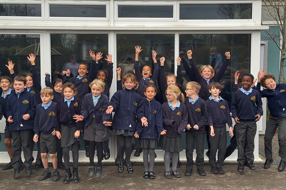 A mixed group of children from Holy Trinity School jumping and celebrating